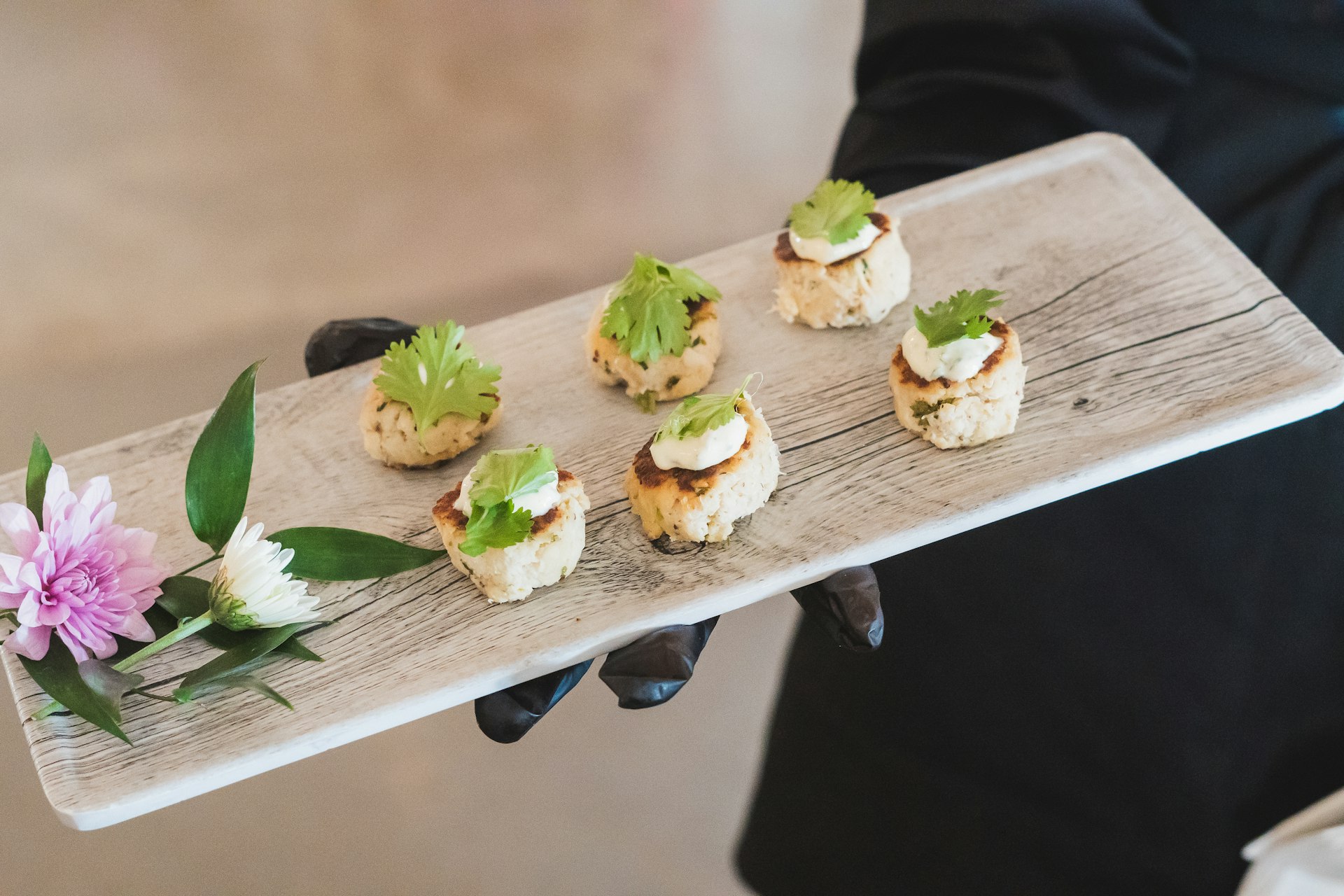 A person holding a tray with small appetizers on it